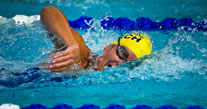 Chica nadando crol en el carril de una piscina